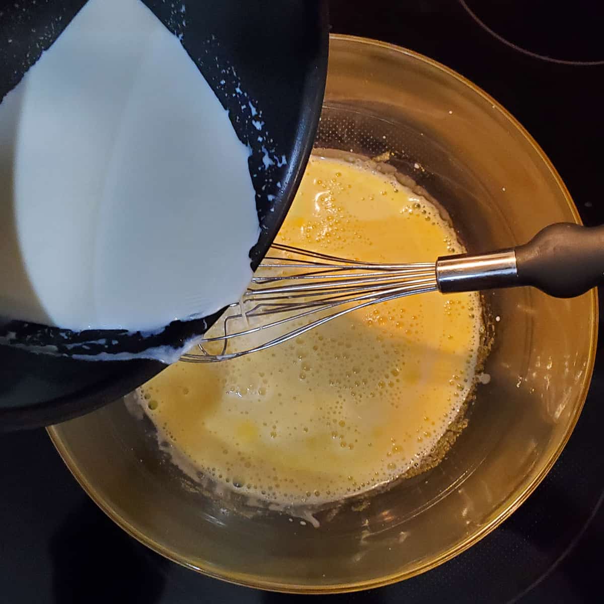 Chocolate custard mixing cream into eggs and sugar
